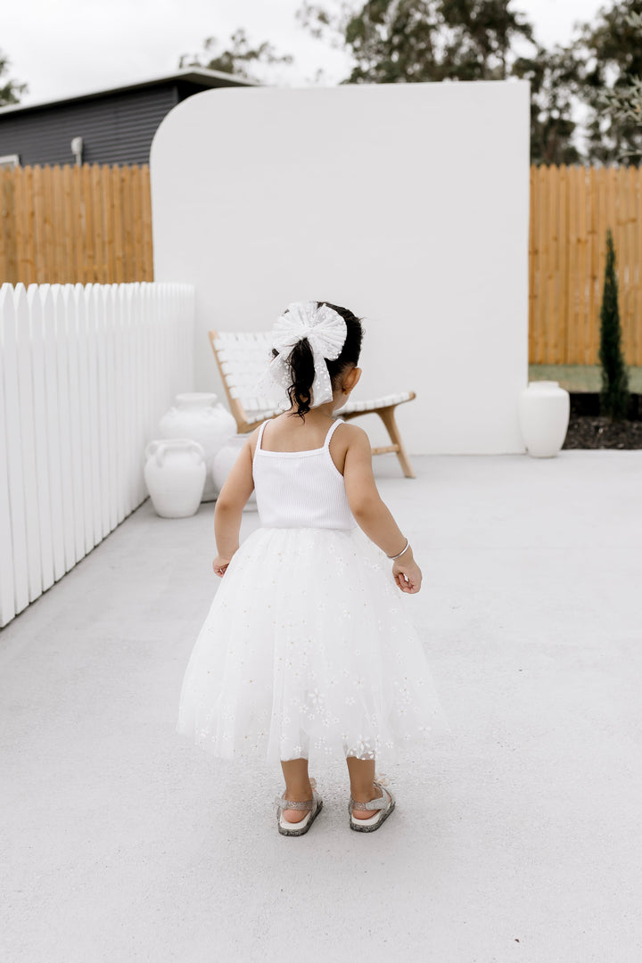 Girl wearing the Golden Daisies ribbed tulle dress, full length