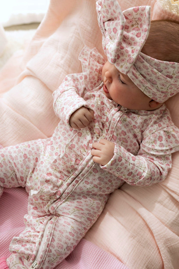Baby in the Seashell Bloom Zipsuit and matching headpiece, close view (headpiece not included)