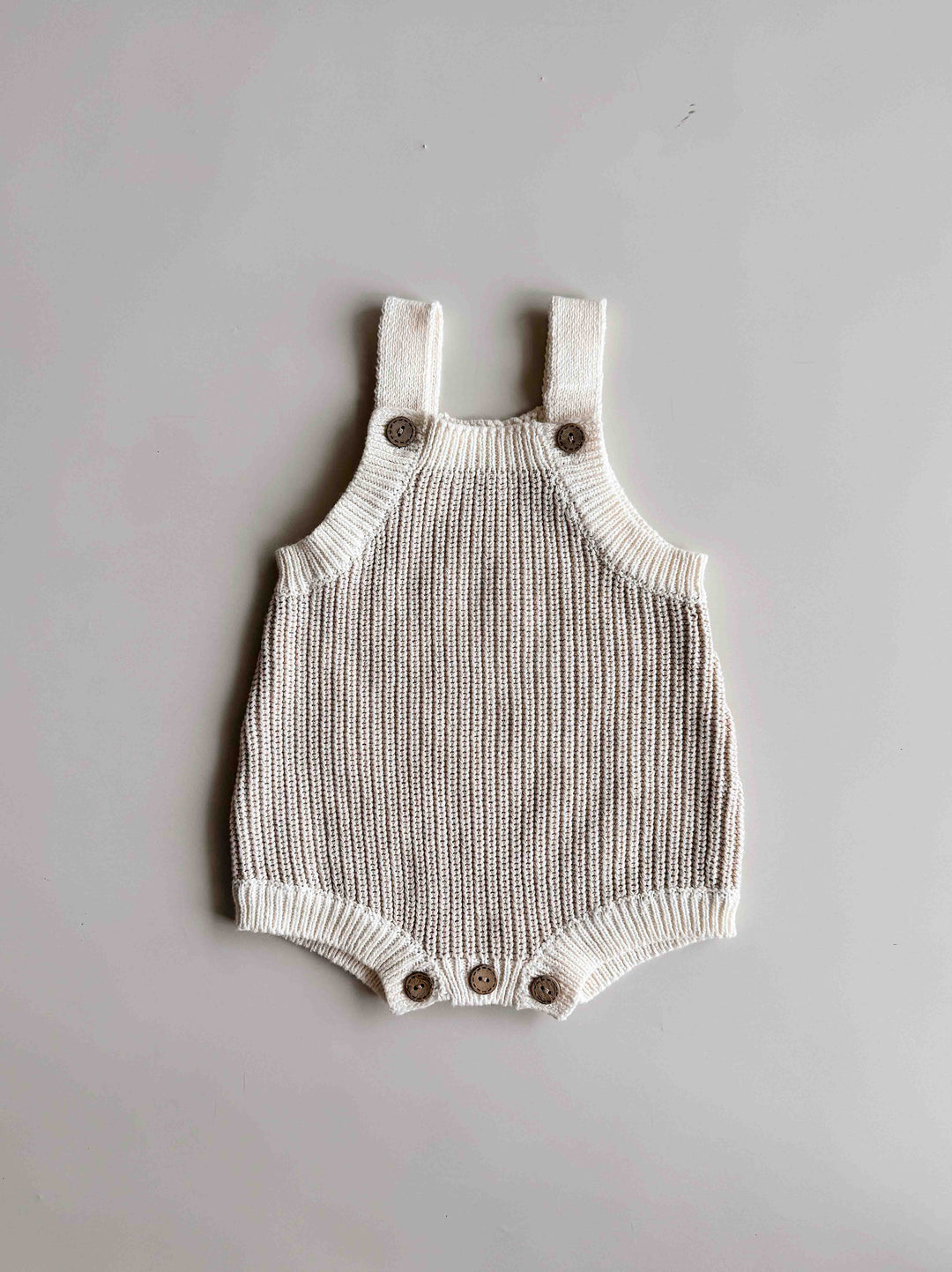 Freckles The Label Chunky Button Romper in Oat laid flat, with button suspender straps