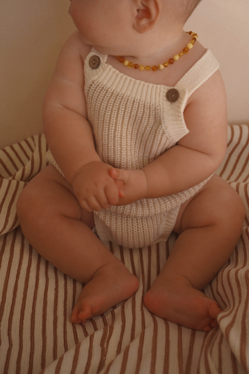 Baby wearing the Freckles The Label Chunky Button Romper in Oat