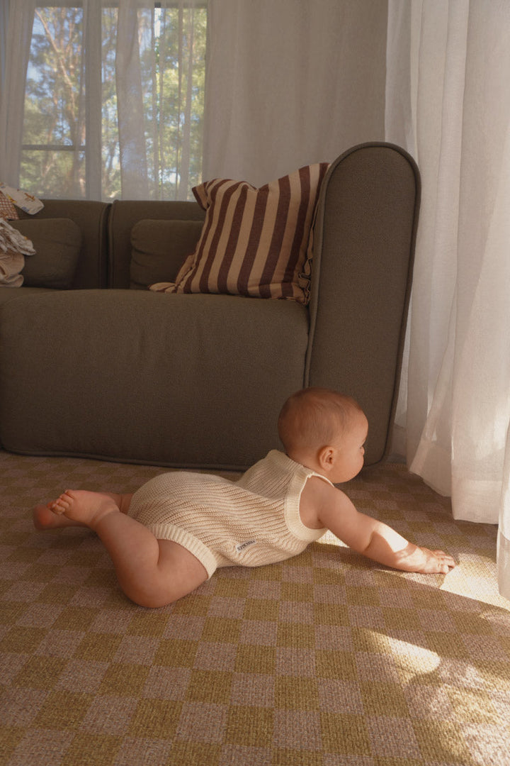 Baby crawling in the Freckles The Label Chunky Button Romper in Oat