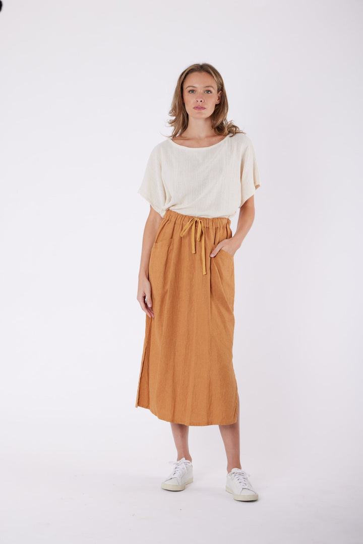 Isla Linen Midi Skirt in Tanzine, worn with a cream top, model shot 1