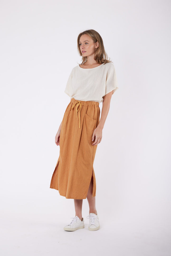 Isla Linen Midi Skirt in Tanzine, worn with a cream top, model shot 3